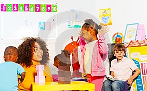 Happy girl play with teacher building blocks