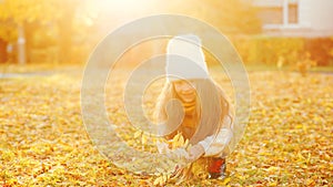 Happy girl playing with autumn leaves. Happy child walking and having fun in fall backyard