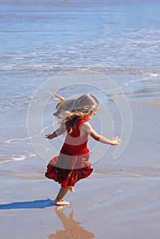 Happy girl playing on the beach