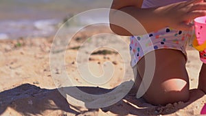 Happy girl playing with easter eggs on the beach