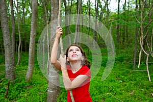 Happy girl playing in forest park jungle with liana