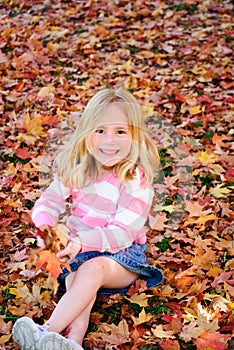 Happy girl playing in leaves