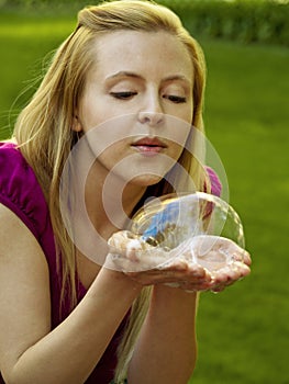 Happy girl playing with soap bubbles