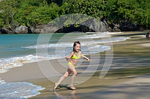 Happy girl plays in sea on tropical beach