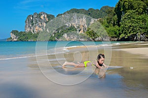 Happy girl plays in sea on tropical beach