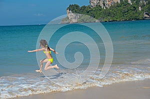 Happy girl plays in sea on tropical beach