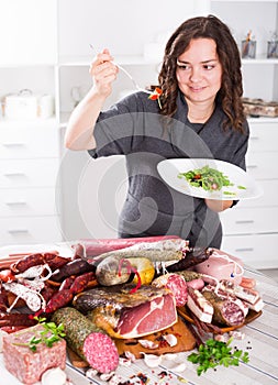 Happy girl prefers to eat greens and salad