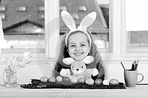 Happy girl with rabbit toy, pencil, tulip flowers, easter eggs