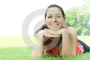 Happy girl relaxing on green grass