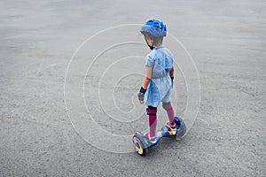 Happy girl riding on gyroscooter outdoors. Active life concept. Child rides on hover board in protective gear helmet
