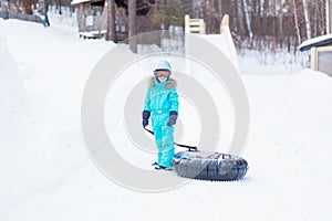 Happy girl riding on a sled on a mountain high