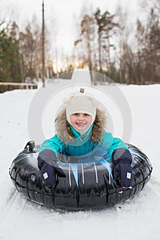 Happy girl riding on a sled mountain high