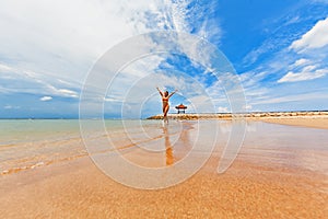 Happy girl run by wide sand beach