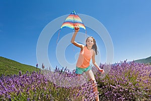 Happy girl running with kite in lavender field