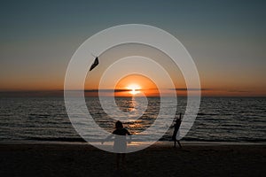 happy girl running with a kite at sunset outdoors. A child runs with a kite at sunset against the backdrop of the sea