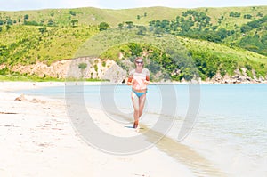 Happy girl running on the ocean beach