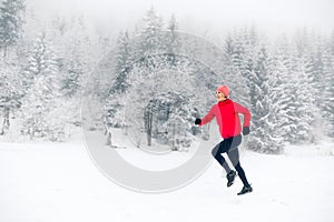 Happy girl running on snow in winter mountains.