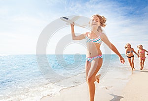 Happy girl runs with airplane model on the beach
