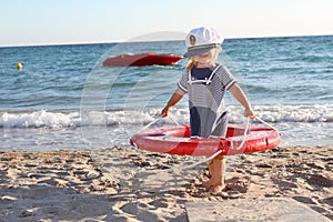 Happy girl in sailor hat on beach