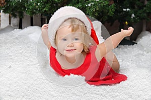 Happy girl in santa costume on snow