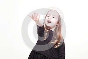 Happy girl in santa hat with christmas toys on white background. Funny young child waiting for christmas, new year and presents.