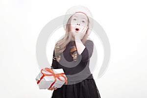 Happy girl in santa hat with gift on white background. Funny young child waiting for christmas, new year and presents. holiday,