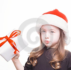 Happy girl in santa hat with gift on white background. Funny young child waiting for christmas, new year and presents. holiday,