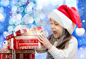 Happy Girl in Santa Hat Opening a Gift Box