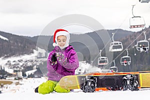 Happy girl in santa hat with snowboard