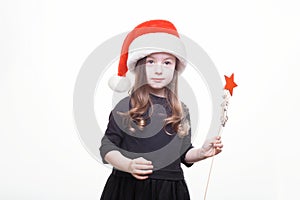 Happy girl in santa hat with star in her hand. Funny young child waiting for christmas, new year and presents. holiday, sale