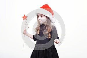 Happy girl in santa hat with star in her hand. Funny young child waiting for christmas, new year and presents. holiday, sale