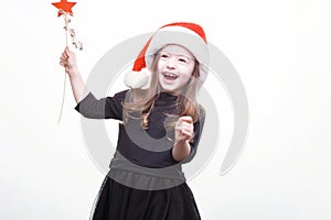 Happy girl in santa hat with star in her hand. Funny young child waiting for christmas, new year and presents. holiday, sale