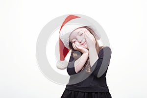 Happy girl in santa hat on white background. Funny young child waiting for christmas, new year and presents. holiday, sale concept