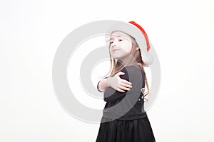 Happy girl in santa hat on white background. Funny young child waiting for christmas, new year and presents. holiday, sale concept