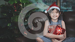 Happy girl in Santa red hat holding Christmas presen.Concept of Christmas and child