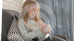 Happy girl save money in piggy bank in her home. Child inserting a coin into a piggy bank, indoor financial concept. Kid