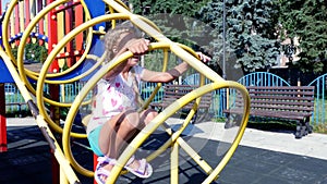 Happy girl of seven years playing on playground, having fun on hot summer day. Slow motion . Joyful active childhood.