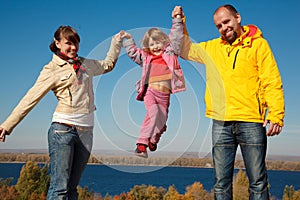 Happy girl shakes on hands at parents