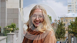 Happy girl with shopping packages walks on street in city Caucasian woman whirling with bags outdoor female shopper