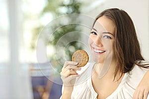 Happy girl showing a dietetic cookie photo