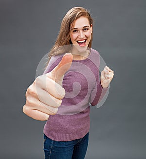 Happy girl showing large thumbs up with willing body language