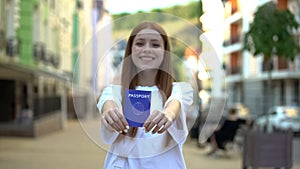 Happy girl showing passport before camera, adulthood, step into adult life