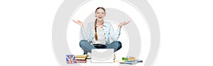 Happy girl sitting on floor with laptop, books and copybooks, uk flag and gesturing