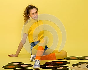 Happy girl sitting on floor with vinyl records