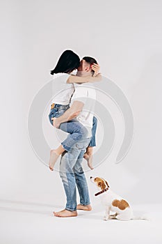 A happy girl is sitting in the hands of a her boyfriend, they are dancing and having fun. Beautiful woman jumps in arms