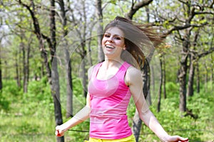 Happy girl with a skipping rope in a summer park