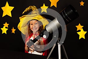 Happy girl in sky watcher costume with a telescope