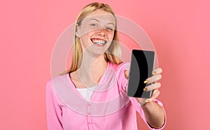 Happy girl with smartphone with empty screen. Advertising new model. Beautiful woman shows mobile phone.