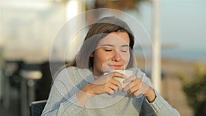 Happy girl smelling coffee aroma in slow motion