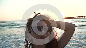 Happy girl spinning and dancing on beach at sunset